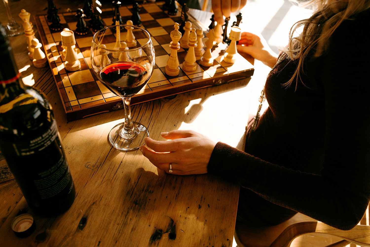 Sudbury Ontario laurentian university engagement photography of woman holding a glass of red wine while playing chess