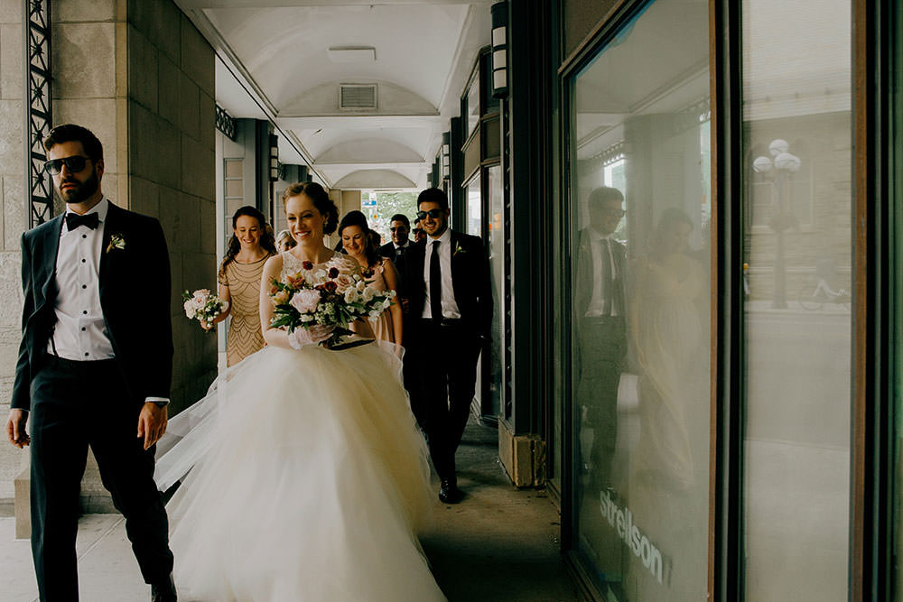 bridal party walks together between buildings downtown Toronto