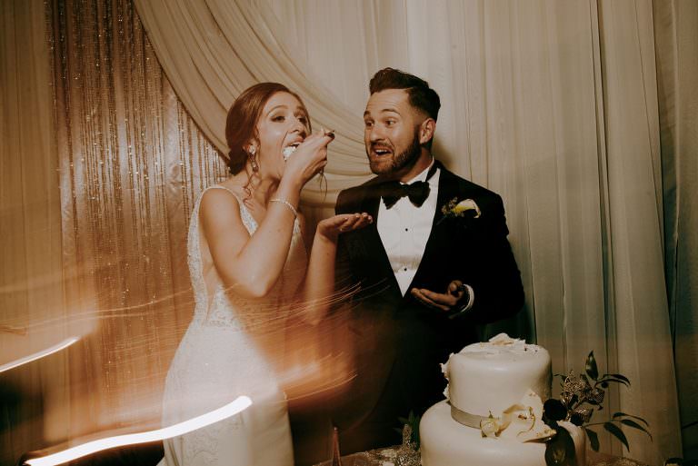 Caruso Club Sudbury Ontario Wedding photography of bride and groom eating their first piece of cake after cutting the cake