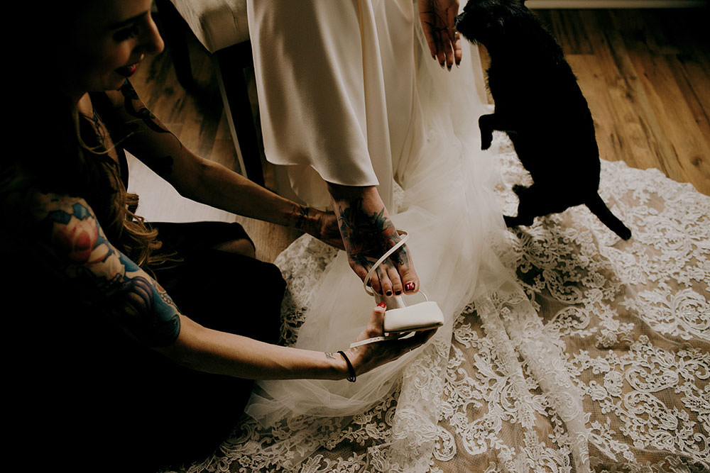 Bridesmaid helps bride put on her shoe