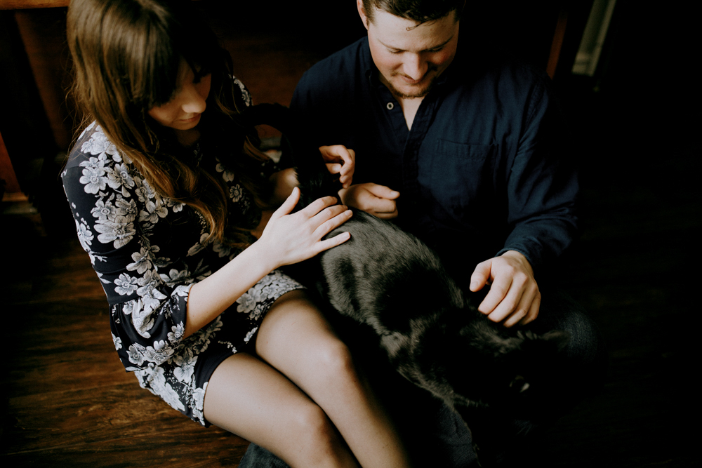 couple plays with cat in engagement photography session in their innisfil home