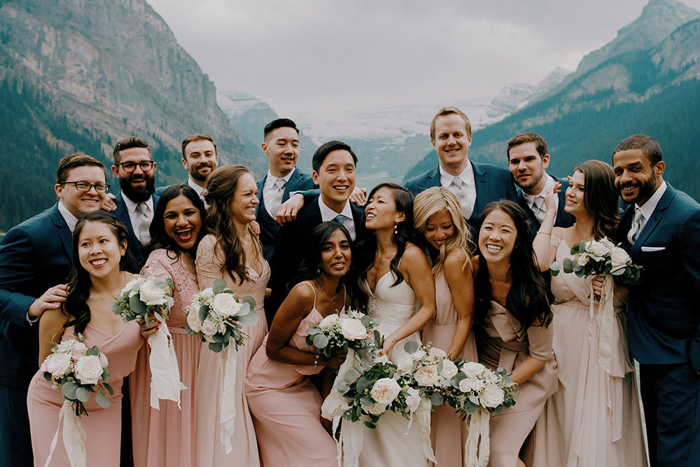 fairmont lake louise bridal party portrait of them popping champagne bottle in celebration