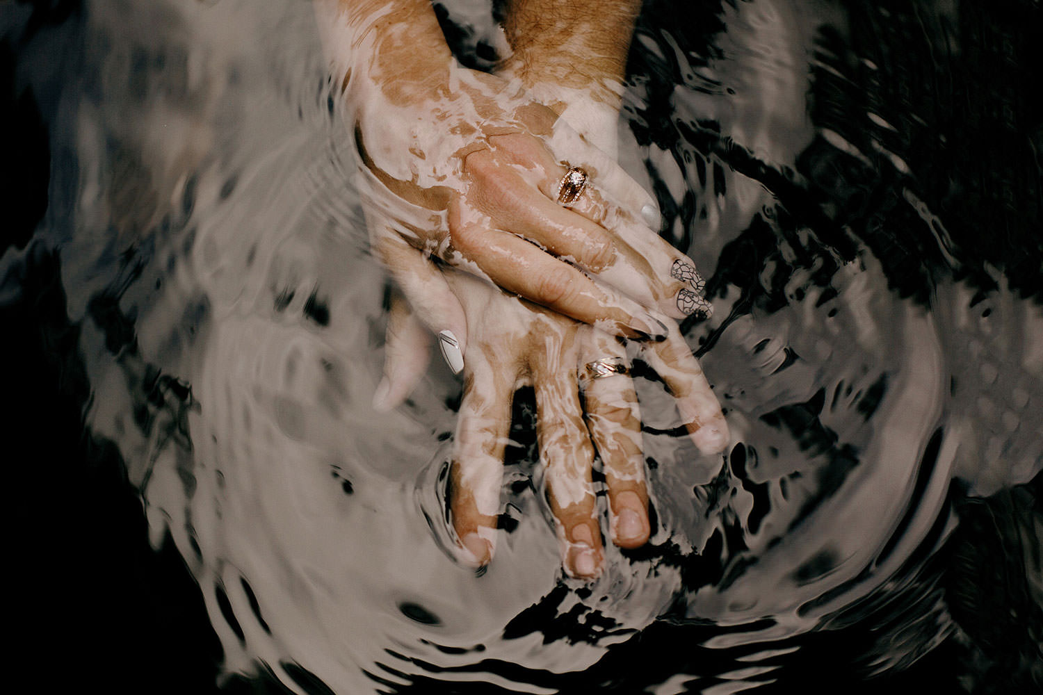 Belize wedding photography detail of couple holding hands in the water at the cockscomb wildlife conservation waterfall