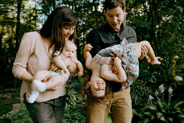 sudbury Ontario family photography of mom and dad holding their two kids upside down and laughing