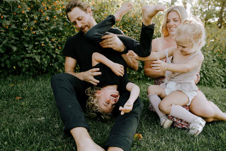 sudbury Ontario family portrait of Andrew Desjardins holding his son upside down and laughing