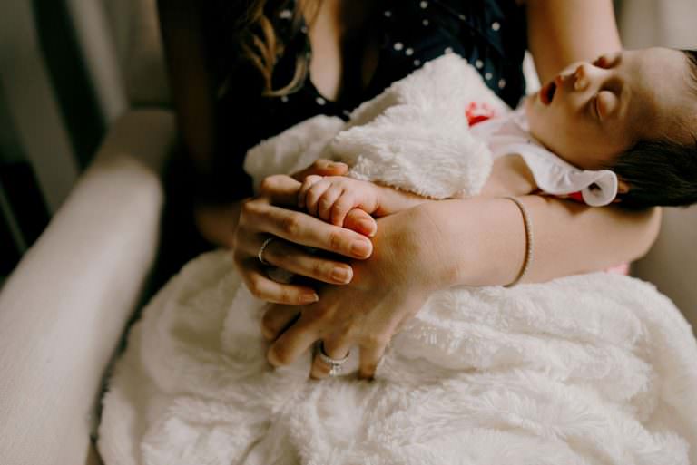 mom holds her sleeping newborn during a photography session in Sudbury ON