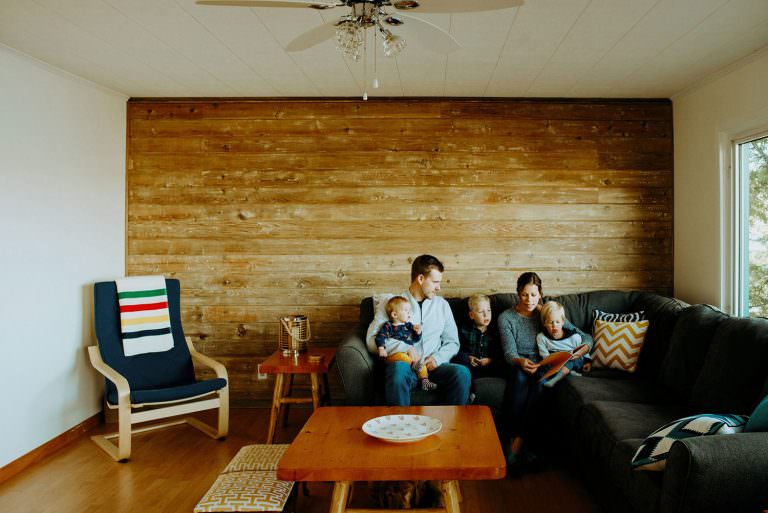 Family Photography session of family reading a book together in their living room in Sudbury Ontario