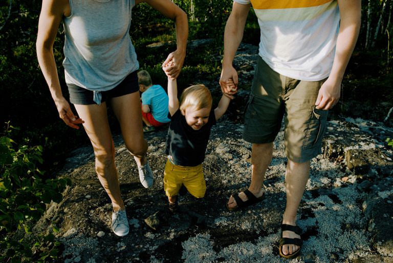 mom & dad swing baby during a fun family photography session in sudbury Ontario