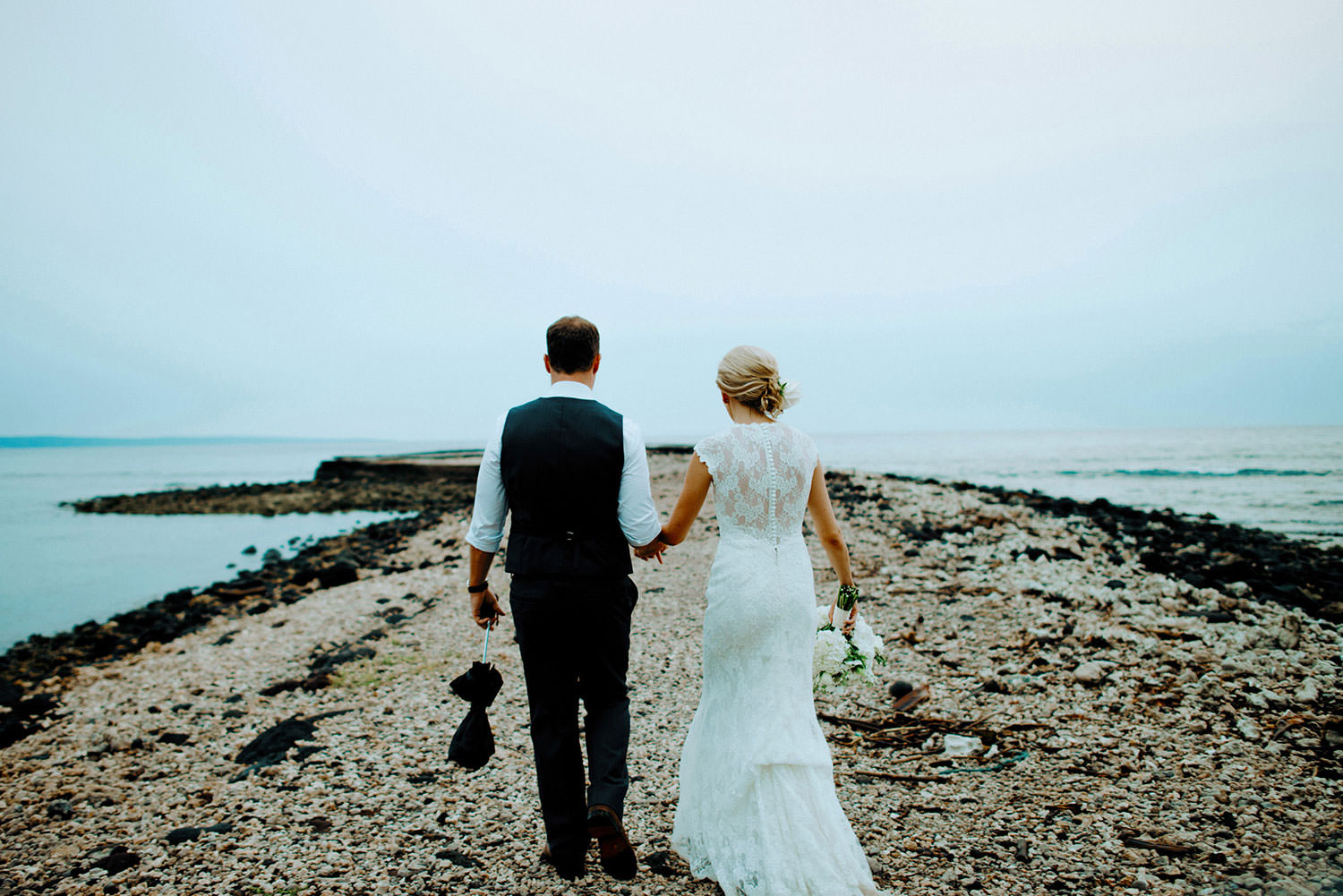 Maui wedding photography of couple holding hands walking out to the ocean