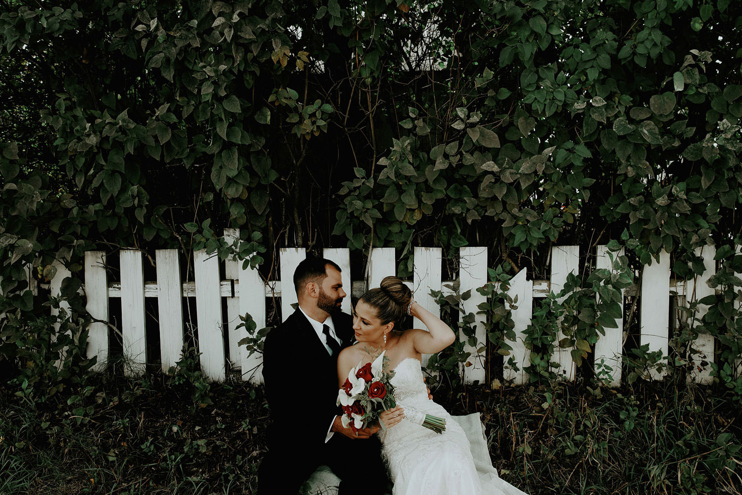 sudbury Wedding photography of couple posing in front of white picket fence