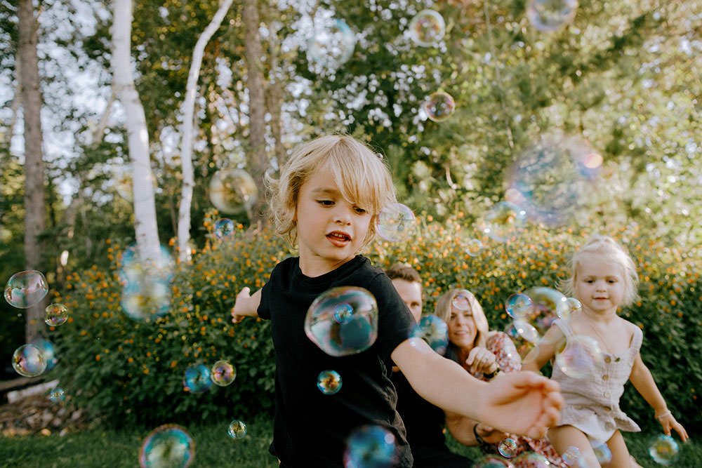 Andrew Desjardins and family chasing bubbles for Ontario family portrait
