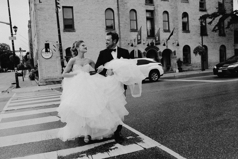 Paris Ontario Wedding photography of bride and groom crossing the street holding hands and staring at one another