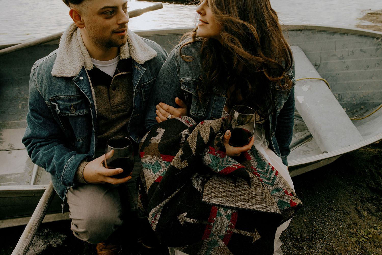 sudbury engagement photography of the couple sitting on a boat drinking some wine