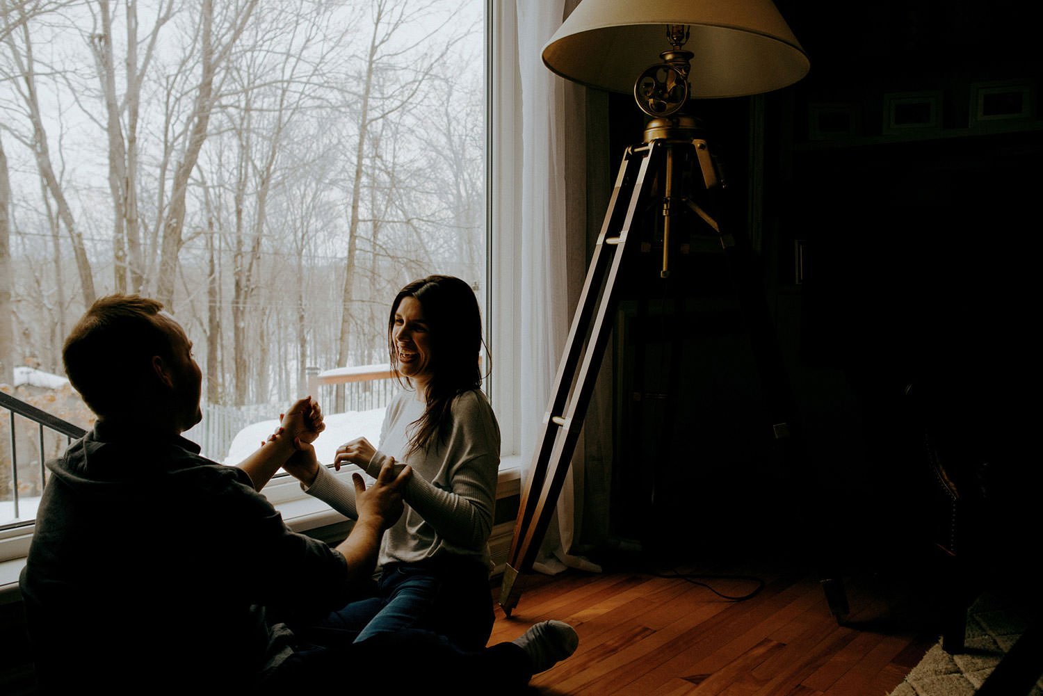 Sudbury Ontario Engagement photography of couple laughing candidly in their cozy living room