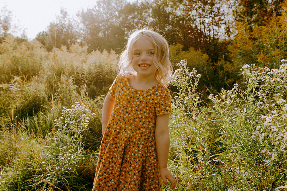 Sudbury family photography of daughter laughing in flower field