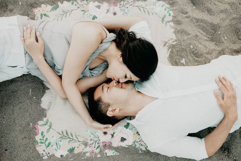 toronto Ontario beach engagement photography of couple laying head to head sharing a kiss