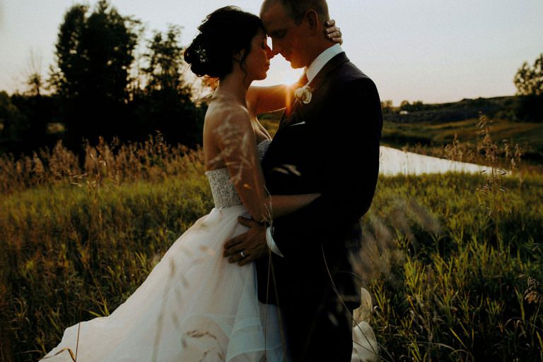 Sudbury Ontario wedding photography of bride and groom embracing with the sunset in the backdrop