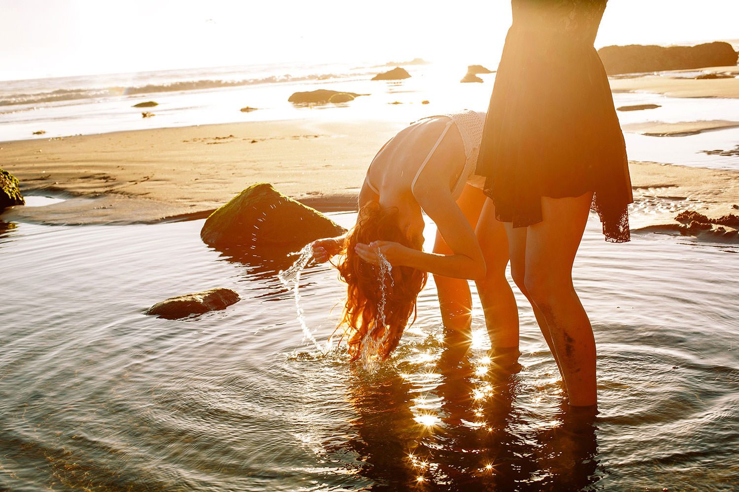 Models Kimberly-Sue Murray snd Emily Coots splash in water at the seal rookery in Carpinteria California