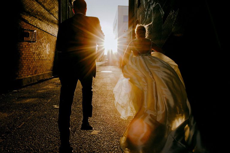 wedding couple runs toward the sunset in sudbury Ontario wedding photography