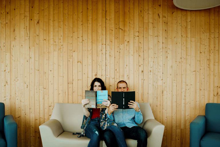 school of architecture Sudbury Ontario engagement photography of couple hiding playfully behind their books