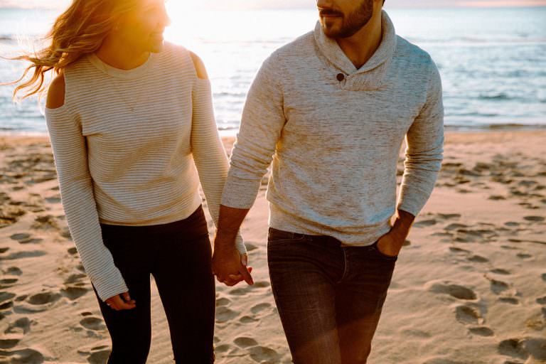 Toronto engagement photography of couple walking on the beach at the bluffs in Ontario