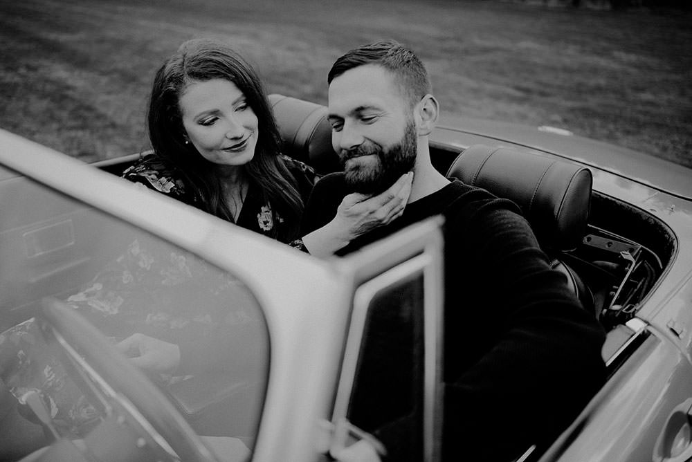 Fairbanks Ontario engagement photography of couple holding each other on MGB classic car