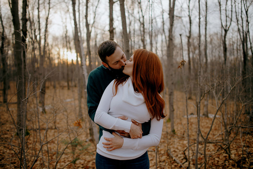 Fairbanks Ontario engagement photography of couple kissing in fall woods