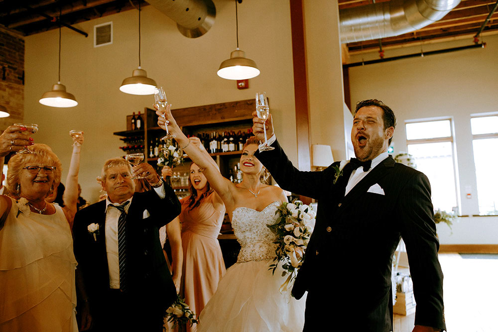 Best Wedding reception Photography of bride and groom raising a glass