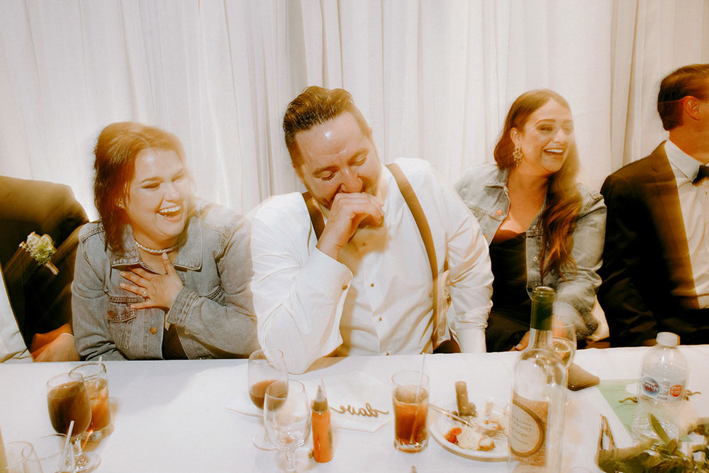 Best Wedding reception Photography of bridal party laughing at speech