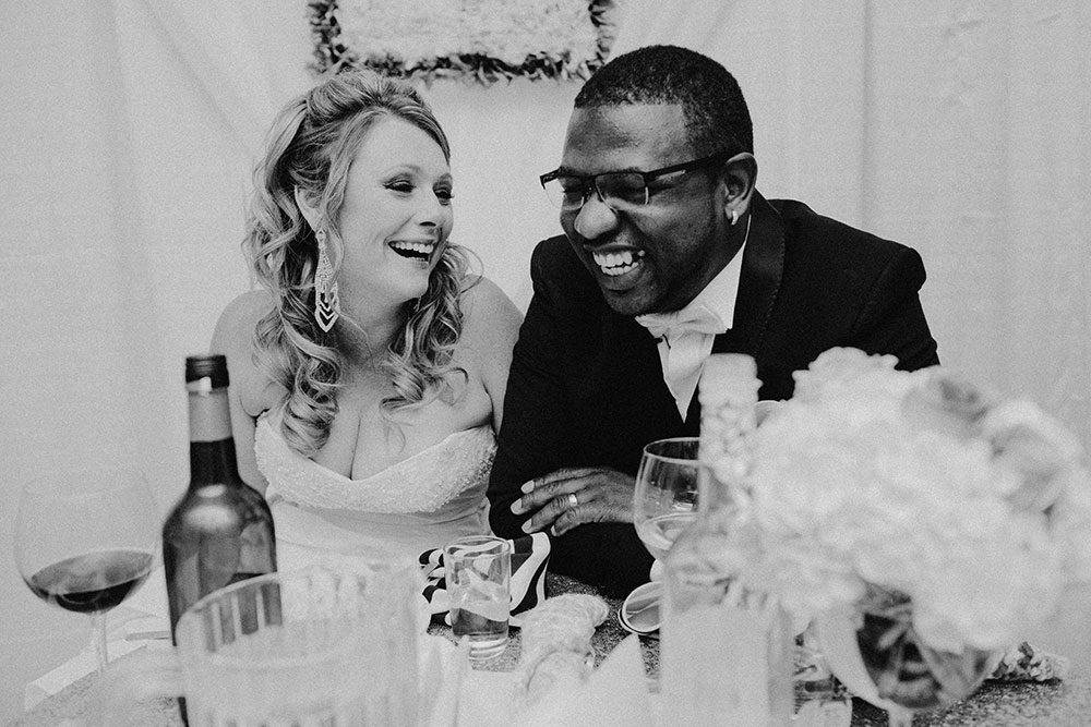 Best Wedding reception Photography of bride and groom laughing at speech