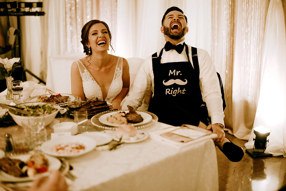 Best Wedding reception Photography of bride and groom laughing at speech