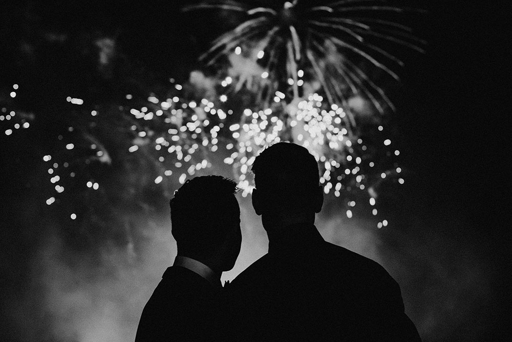 Best Wedding reception Photography of groom and groom watching fireworks together