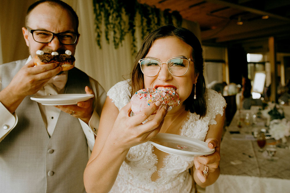 Best Wedding reception Photography of bride and groom sharing donuts