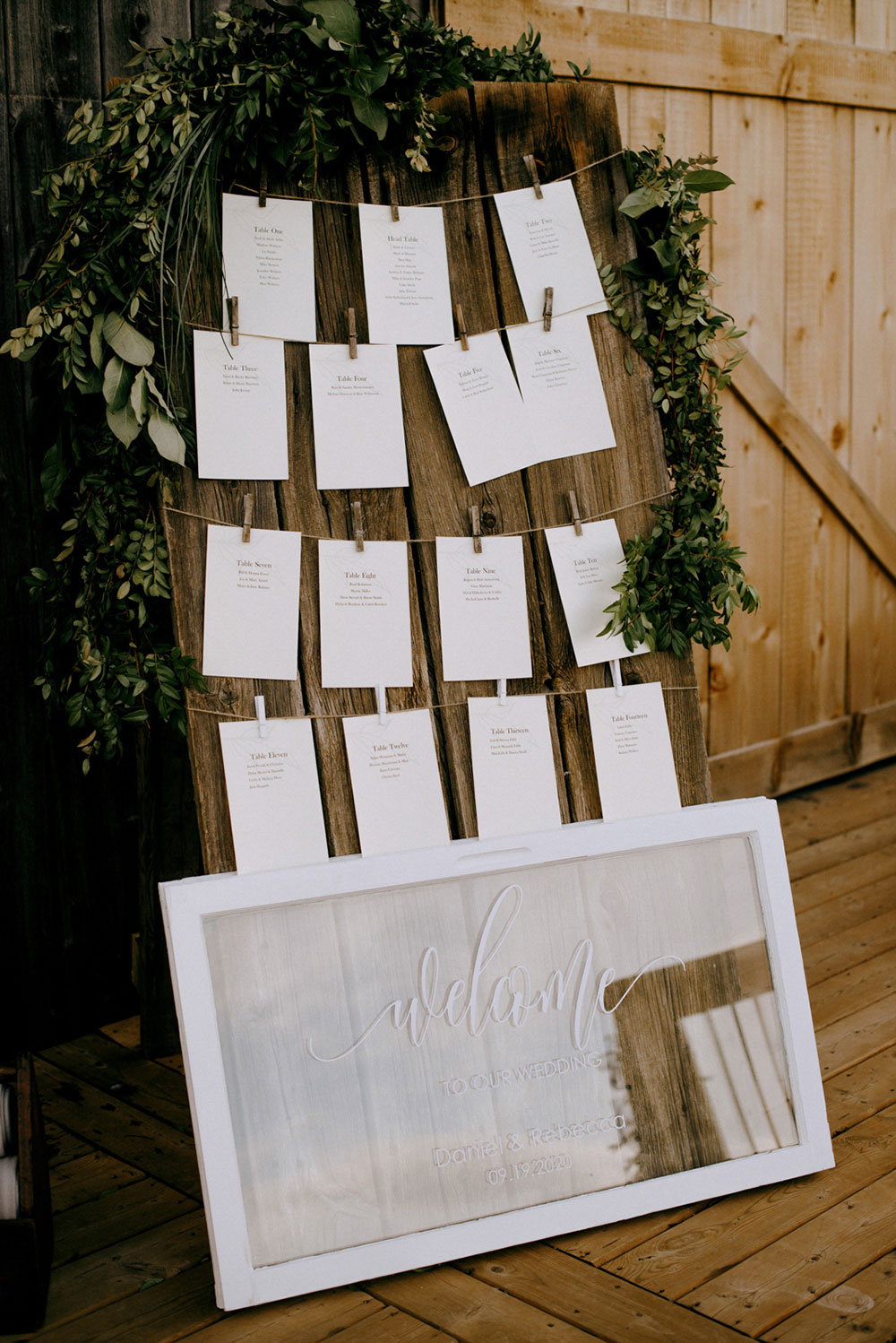 table cards hang from string and clothespins at the entrance of this barn wedding at the heritage view barn