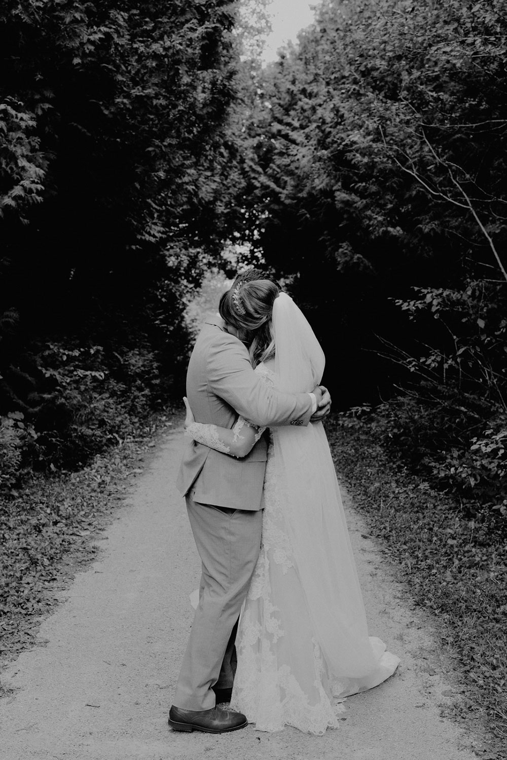 a warm embrace between husband and wife on a nature trail