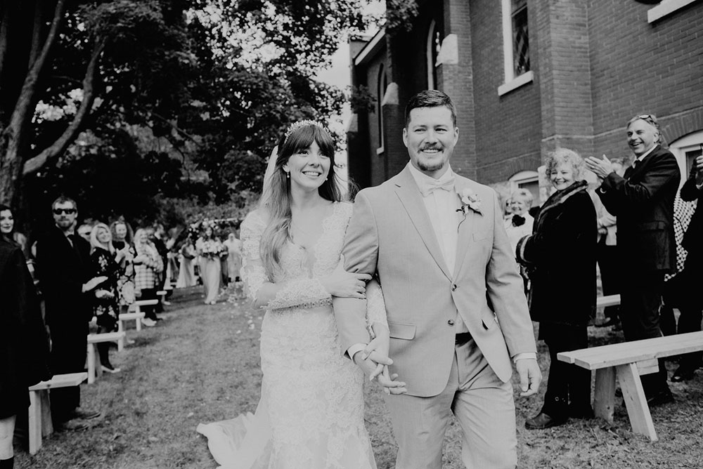 bride and groom smile and walk down the aisle as they are pronounced husband and wife