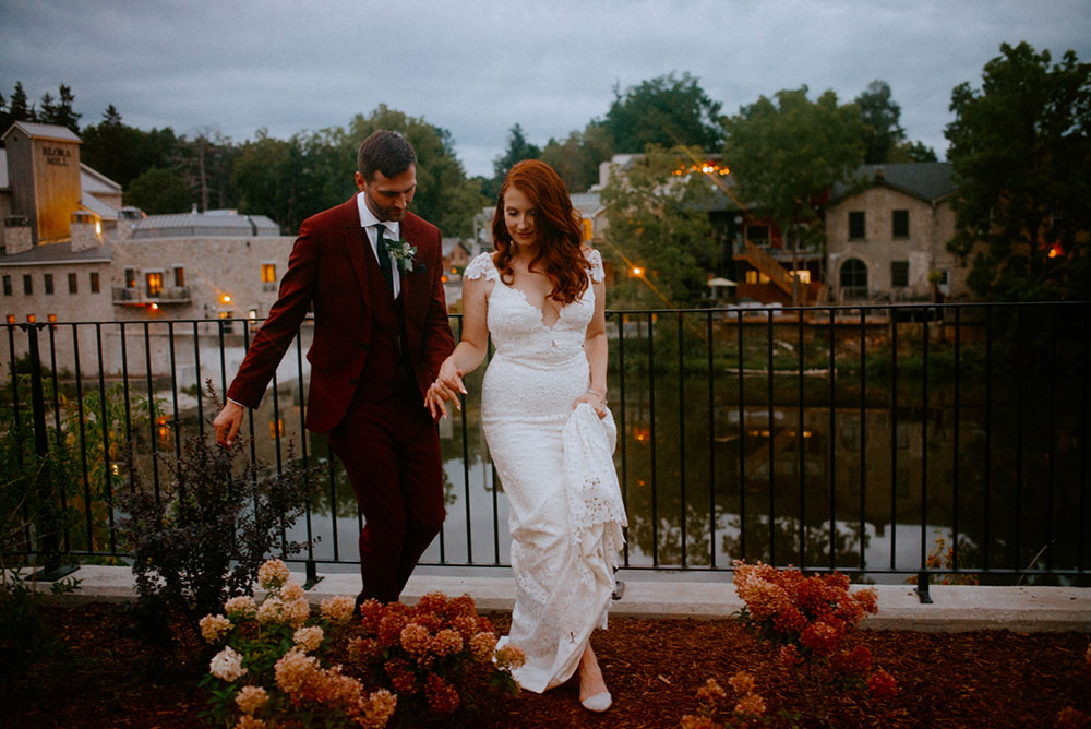 elora mill hotel elopement bride and groom dance through the downtown as husband and wife