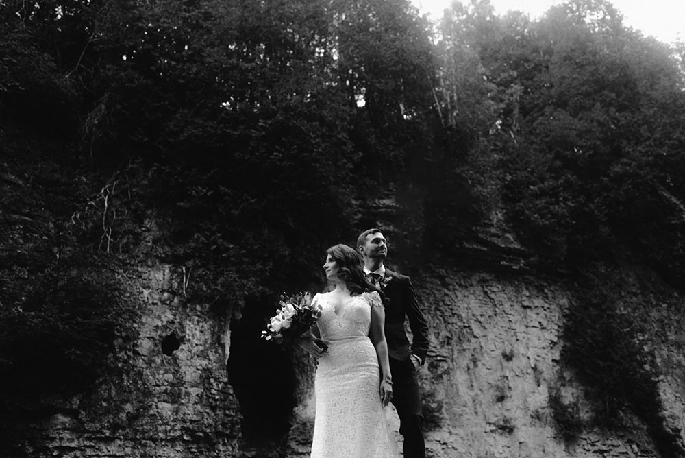 elora mill hotel elopement bride and groom walk through the victoria park gorge as husband and wife