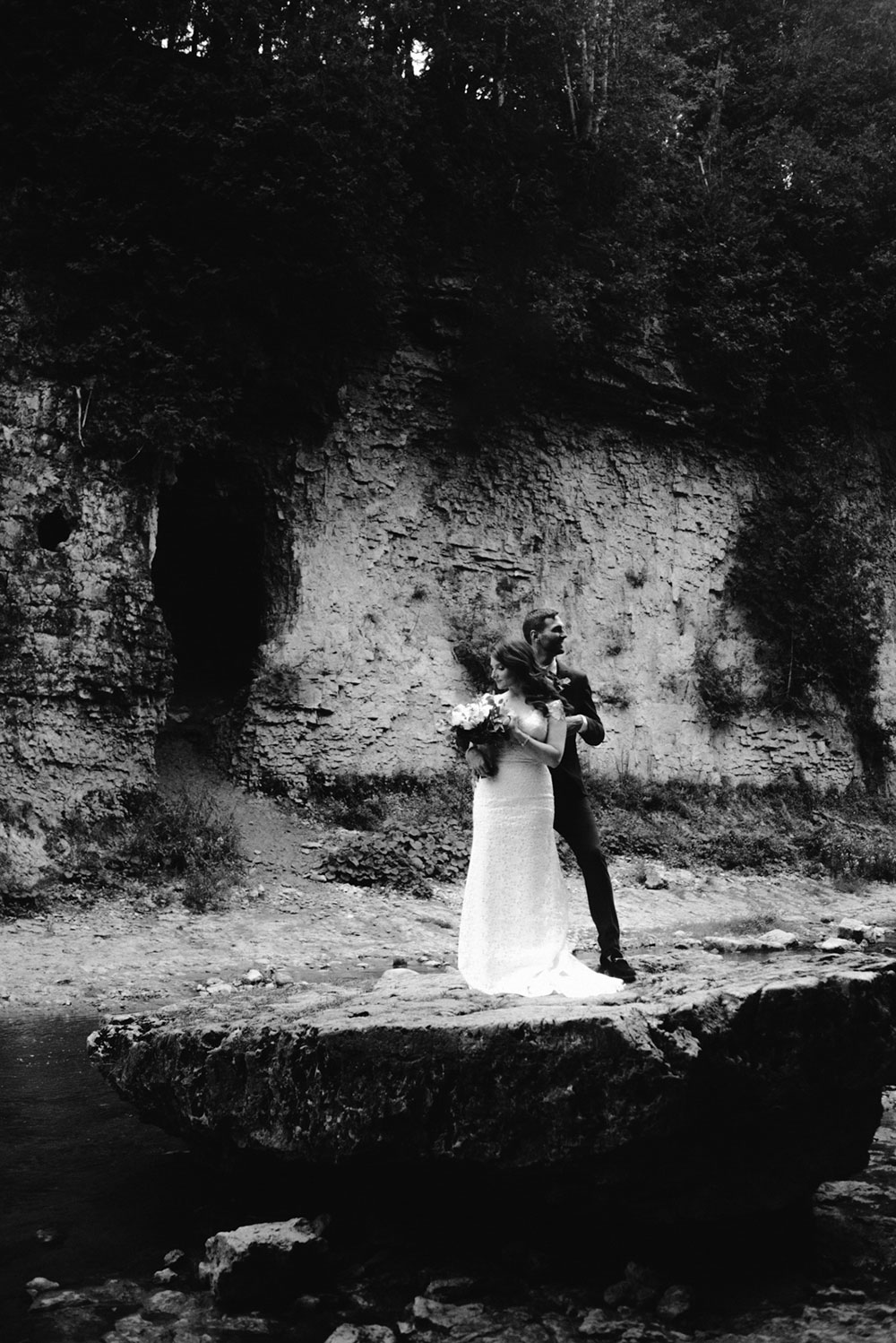 elora mill hotel elopement bride and groom walk through the victoria park gorge as husband and wife