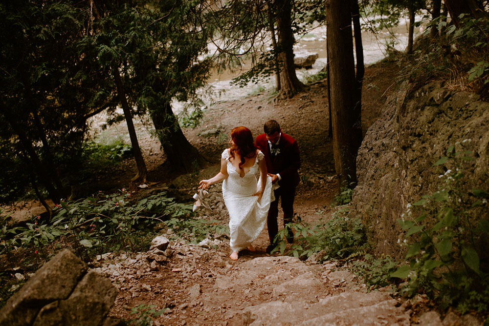 elora mill hotel elopement bride and groom walk through the victoria park gorge as husband and wife