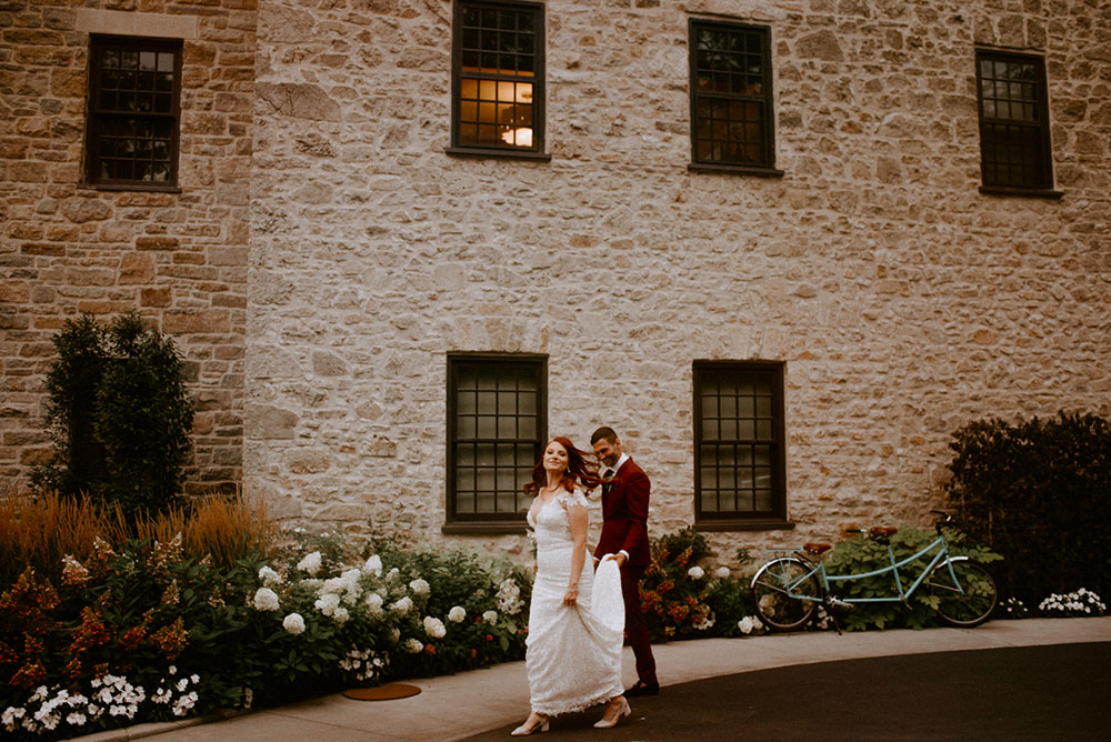 elora mill hotel elopement bride and groom dance through the downtown as husband and wife