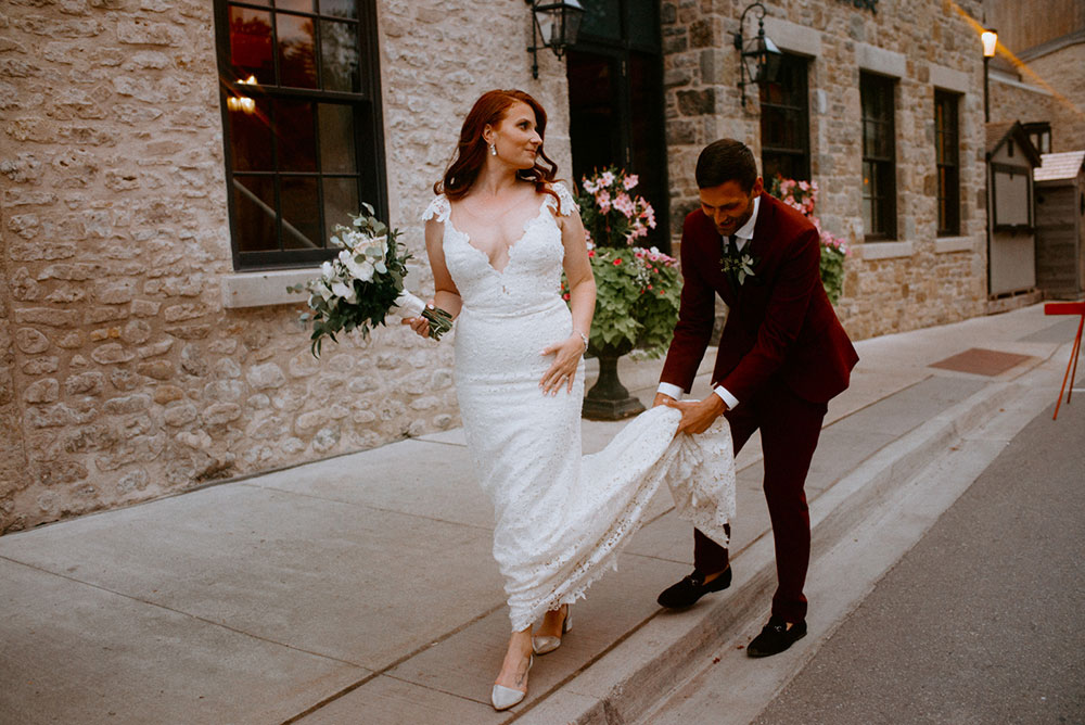 elora mill hotel elopement bride and groom dance through the downtown as husband and wife