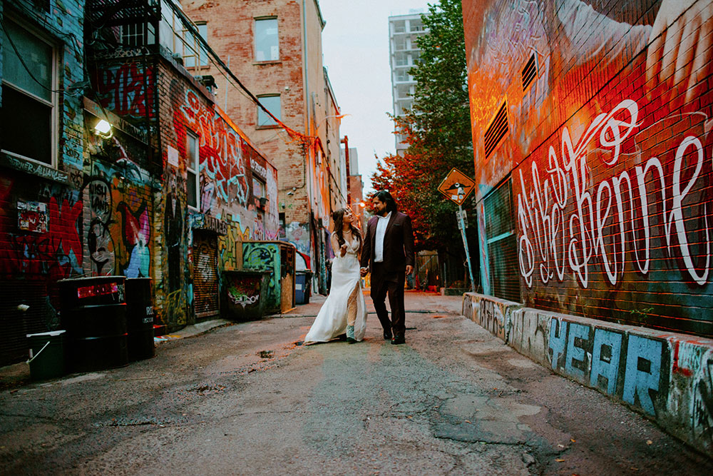 The Burroughes Toronto Wedding Couple candidly run around Graffiti Alley in Toronto