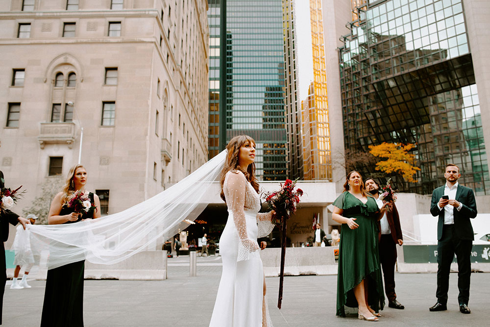 The Burroughes Toronto Wedding Bride walks around Union Station Entrance with Wedding Party