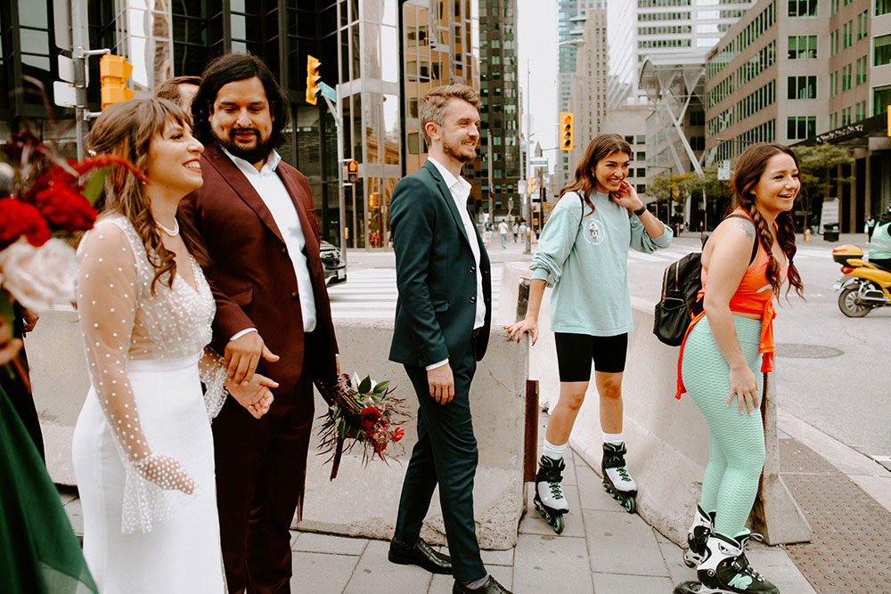 The Burroughes Toronto Wedding Couple walk candidly by roller bladers near Union Station 