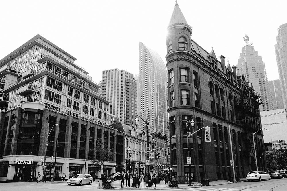 The Burroughes Toronto Wedding Party stand in front of the Gooderham Building in Toronto