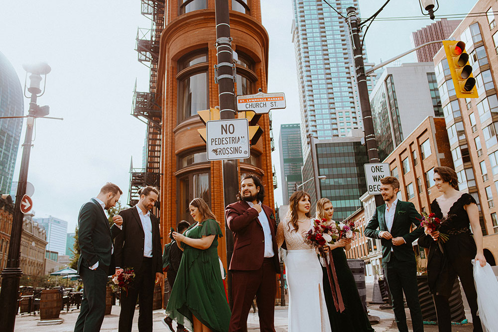 The Burroughes Toronto Wedding Party stand in front of the Gooderham Building in Toronto