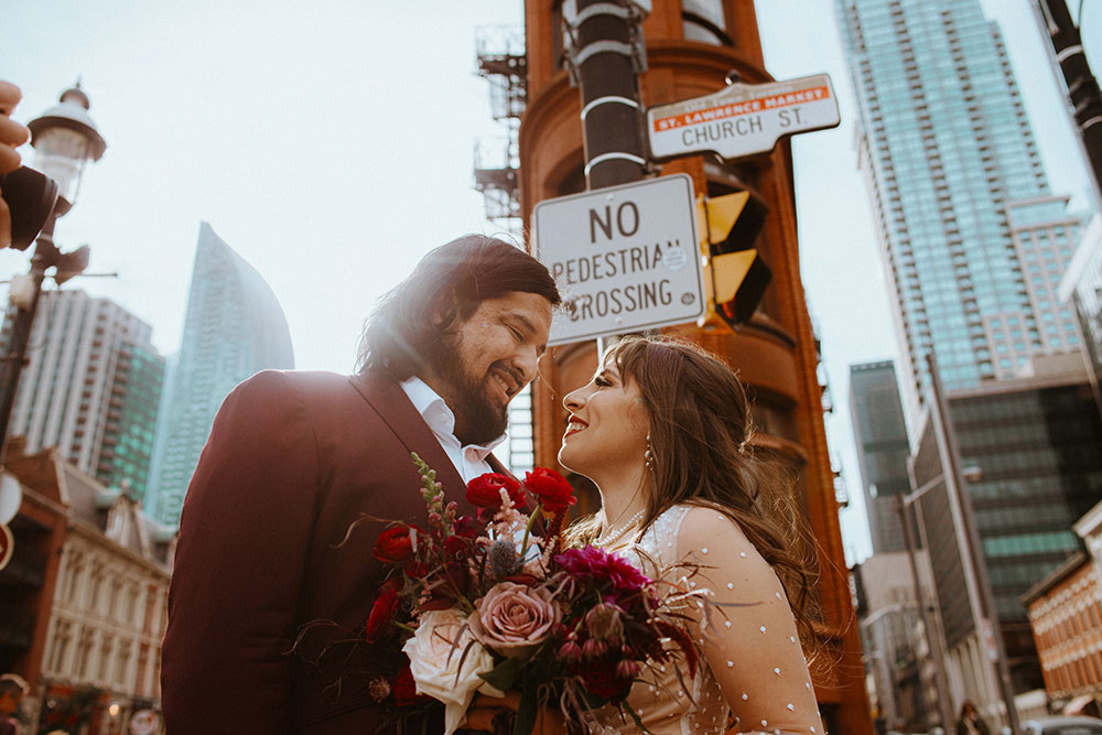 The Burroughes Toronto Wedding Couple stand in front of the Gooderham Building in Toronto