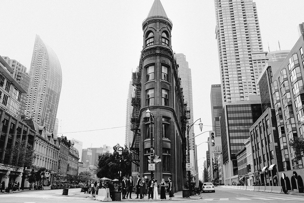 The Burroughes Toronto Wedding Party stand in front of the Gooderham Building in Toronto