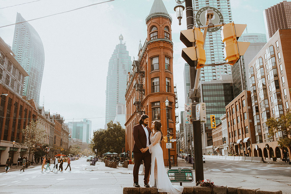 The Burroughes Toronto Wedding Couple stand in front of the Gooderham Building in Toronto